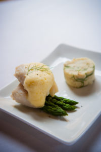 Poached cod with a roasted fennel mash, asparagus tips, and roasted carrot espuma.