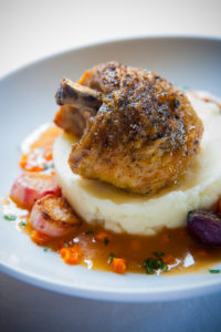 Roasted herb chicken with whipped butter potatoes, roasted radishes, carrots, and pearl onions in chicken jus.